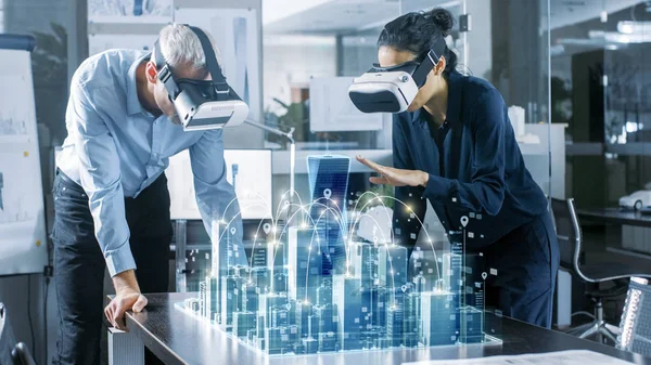 Erkek ve dişi Mimarlar giyen gerçeklik kulaklık iş 3d şehir modeli ile artar. High Tech Office profesyonel insanlar sanal gerçeklik modelleme yazılımı kullanın.