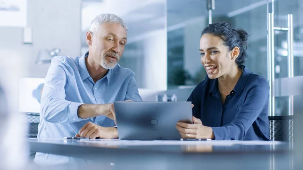 Erfarne Mannlige Kvinnelige Kontorarbeidere Diskuterer Pågående Prosjekt Mens Arbeider Laptop – stockfoto