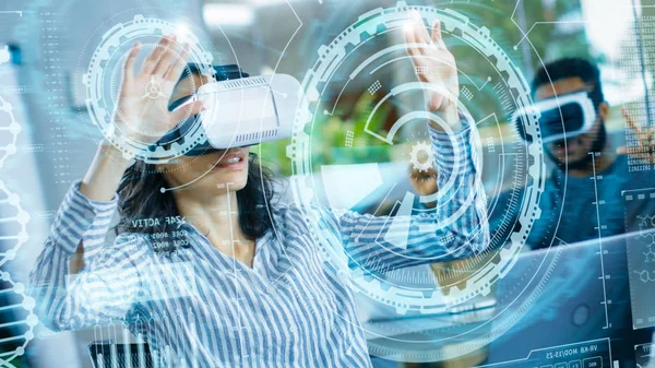 女性虚拟现实工程师 开发人员佩戴虚拟现实耳机创建与她的同事的内容 在增强和混合现实项目中 聪明的年轻人用全息图工作 — 图库照片