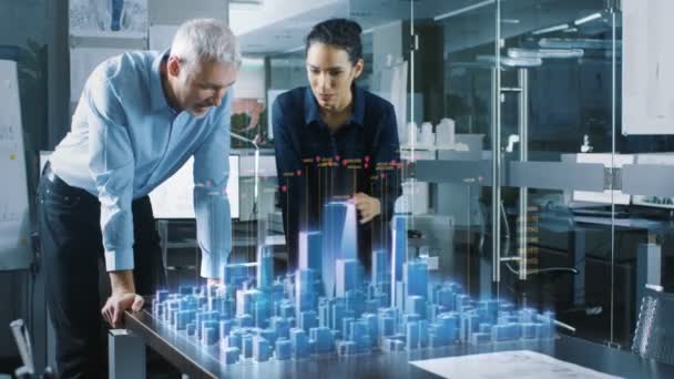 男性和女性建筑师的工作与全息增强现实3D 城市模型 技术先进的 Office 专业人员使用虚拟现实建模软件应用程序 — 图库视频影像