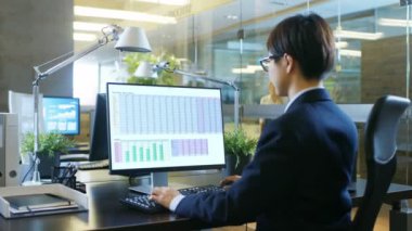 Elektronik tabloları, çizelgeleri ve istatistikleri ile kişisel bilgisayarda Office işadamı çalışır. Meslektaşı onu karşısında oturuyor. Beton ve cam Stylishy odam.
