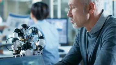 Robot mühendisi yöneten Ses Kontrollü Robot, Laptop ekran gösterir konuşma ve yüz tanıma yazılımı. Arka plan robotik Reseatch Merkezi Laboratuvarı.