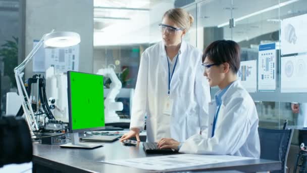 亚洲科学家坐在他的办公桌咨询高级工程师 而在绿色屏幕个人电脑的工作 基于机器人臂模型的计算机科学研究实验室 — 图库视频影像