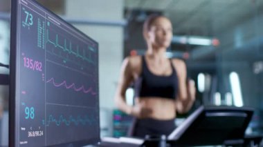 Tıbbi monitör Ekg okuma bir kadın sporcu bir koşu bandı üzerinde çalışan gösterir. Monitörde odaklanmak.