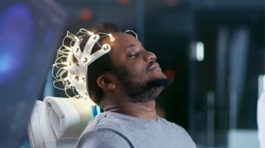 Brainwave giyen laboratuvar erkekte tarama kulaklık kapalı gözlerle bir sandalyede oturuyor. Monitörler Eeg okuma ve grafik beyin modeli gösterir. Modern beyin çalışma / nörolojik araştırma laboratuvarı.