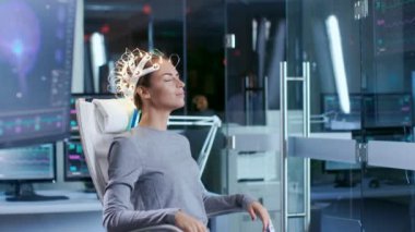 Kadın giyiyor Brainwave tarama kulaklık oturur iken bilim adamı denetleyen bir sandalyede. Modern beyin çalışma laboratuvar monitör Haritayı Eeg okuma ve beyin modeli.