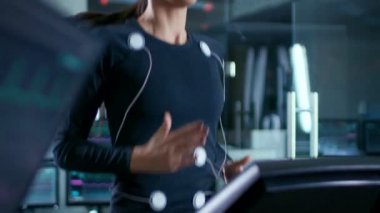 Güzel kadın atlet yürür elektrotlar bağlı bilim adamı denetleyen Her Ekg verileri gösteren laboratuvar monitör üzerinde iken Her vücut ile bir koşu bandı üzerinde.