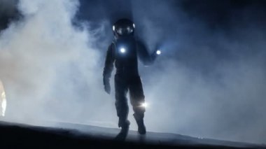 Cesur astronot uzay giysisi içinde el feneri tutar ve sis kaplı gizemli yabancı gezegenin araştırıyor. Macera. Uzay yolculuğu, yaşanabilir Dünya ve kolonizasyon kavramı.