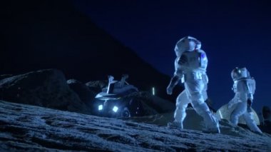 Yabancı bir gezegende uzay elbiseli iki astronot uzay Rover yüzey Araştırma görev için hazır olun. Uzay kolonizasyon hakkında futuristik konsepti.