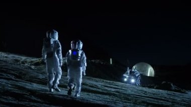 Uzay giysileri içinde iki astronot gökyüzüne bakarak yabancı gezegende yürümek. Jeodezik kubbe ile arka plan Bankası '. Diğer dünyalar kolonizasyon ve uzay seyahat kavramı.