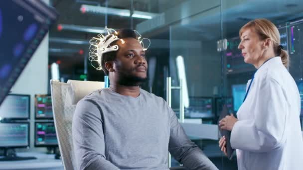 Man Wearing Brainwave Scanning Headset Senta Uma Cadeira Enquanto Cientista — Vídeo de Stock