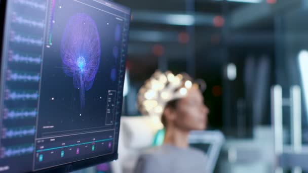 現代脳研究所 神経の椅子に座っている脳波スキャン ヘッドセットを着ている女性研究センター モニターを示す脳波読書と脳のモデル — ストック動画