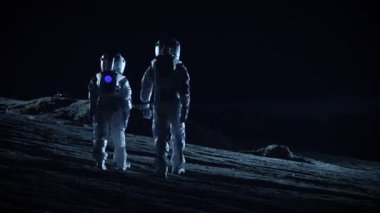 Uzay giysileri içinde iki astronot uzaylı gezegenlerde dünya dışı arazi gözlemleyerek hazır. Uzay yolculuğu ve dünya dışı kolonizasyon kavramı.
