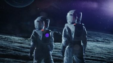 İki astronot alan yabancı gezegende ayakta elbiseli iki güzel gezegen gökyüzünde bakın. Uzay yolculuğu, yaşanabilir Dünya ve kolonizasyon kavramı.