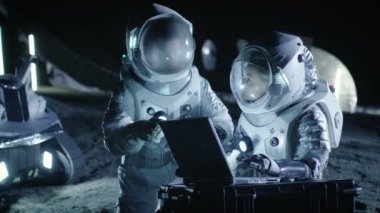 İki astronot uzay giysileri iş üstünde a Laptop giyiyor, keşfetmek yeni gezegen keşfetti, iletişim sinyali Dünya'ya gönder. Uzay yolculuğu, yıldızlararası keşif ve kolonizasyon kavramı.