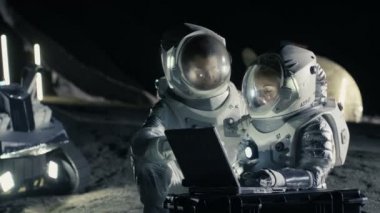 İki astronot uzay giysileri iş üstünde a Laptop giyiyor, keşfetmek yeni gezegen keşfetti, iletişim sinyali Dünya'ya gönder. Uzay yolculuğu, keşif ve kolonizasyon kavramı.