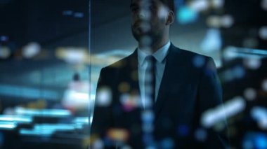 Yakışıklı uygun işadamı görünüyor gece büyük şehirde Office pencereden dışarı. Dünyanın tepesinde başarılı adam.