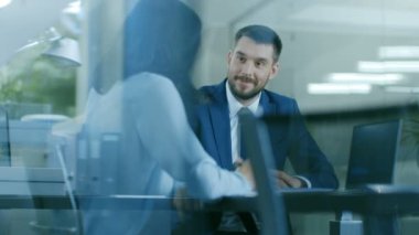 Güzel kadın Yöneticisi tartışma onun masada oturan bir işadamı ile vardır. Modern ofis içinde bir Laptop paylaştıkları anlaşma üzerinde çalışma.