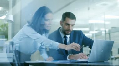 Güzel kadın Yöneticisi danışır yakışıklı O'nun masasında oturan işadamı. Her ikisi de gülümse. Modern ofisindeki bir dizüstü bilgisayar üzerinde çalışan.