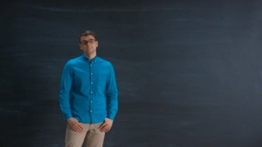 Blackboard karşı duran yakışıklı zeki genç adam, bu ve arka, kurnazca gülümseyerek bakar. Büyük şablon için.