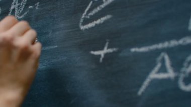 Tebeşir tutarak ve karmaşık ve sofistike matematiksel formül tahtaya yazma el. Alt çizgi denklemi.