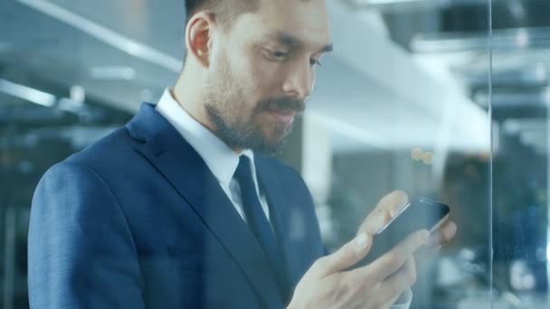 Przystojny Biznesmen Stoi Korytarzu Office Używa Smartfona Robi Gesty — Wideo stockowe