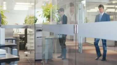 Büyük Office ortağım menajeriyle önemli haberler getiriyor, Tablet bilgisayar bilgileri gösterir. Modern cam ve beton bina olduğunu tam olarak meşgul iş adamları.