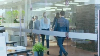 Asya işadamı Rides kaykay kurumsal yapı koridor aracılığıyla uygun. Şık cam ve çok kültürlü kalabalık iş adamları ile beton bina.