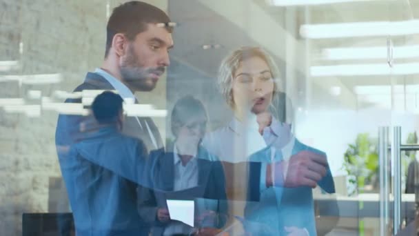 Homme d'affaires et femme d'affaires discutant du plan de travail au bureau du verre. Des gens d'affaires occupés marchent dans le couloir du bâtiment de l'entreprise .