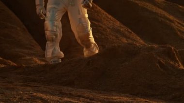 Astronot uzay giysisi giyen kızıl gezegen kayalık arazi üzerinde yürür / Mars. Ayak üzerinde duruluyor. Kayalar ve kum gezegen.