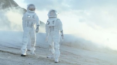 İki astronot uzay giysileri güvenle gezegenin yüzeyinde keşif seferi donmuş yabancı gezegende yürümek içinde. Uzay seyahat, yeni dünyalar keşif, kolonizasyon kavramı. Ağır çekim.