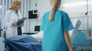 Kolay kadın doktor ziyaret gülümseyen kurtarma Lying yatakta adam, ona sorular ve tıbbi grafik doldurur, ister hemşire yaşam belirtilerini kontrol.