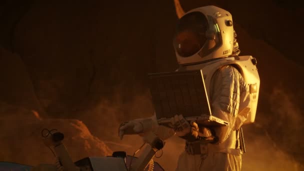 太空服上的航天员在笔记本电脑上工作 在新的外星人红色星球上调整漫游者 大概是火星 日轻高技术空间探索 发现和殖民宜居行星 — 图库视频影像