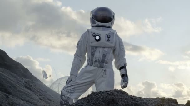 宇宙飛行士を探して周り冷凍エイリアンの惑星の丘の上に立っています 彼のベースの背景 駅を研究します 技術の進歩をもたらす宇宙探検 植民地化 — ストック動画