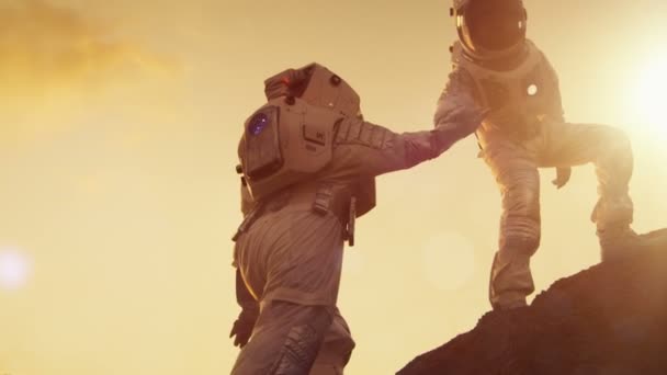 Twee Astronauten Klimmen Berg Heuvel Elkaar Helpen Bereiken Van Top — Stockvideo