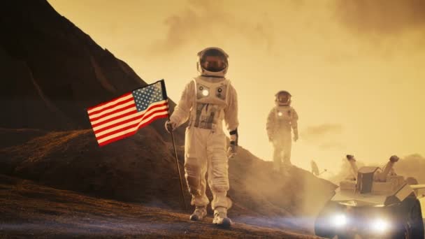 两名宇航员探索火星 红色星球 一个宇航员悬挂美国国旗 技术进步带来太空探索 殖民概念 — 图库视频影像