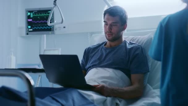 在医院里 在躺在床上的时候 恢复男性患者会使用笔记本电脑 即使生病和在医院工作 护士检查下降计数器 — 图库视频影像