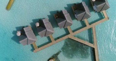 Hava üst aşağı görüntüleri lüks klasik iplik / yüzer Villas üzerinde beyaz kum ve avuç içi ile ana Adası'na bağlı. Turkuaz denizi güzel ayarı.