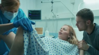Kocası için destek elini tutar Hastanesi Kadın Doğum, yardımcı, Obstetricians vermek için emek iter. Profesyonel ebeler yataklı modern teslimat servis.