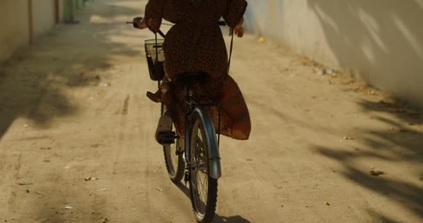 Seguindo Shot Beautiful Woman Vestindo Vestido Passeios Bicicleta Através Narrows — Vídeo de Stock