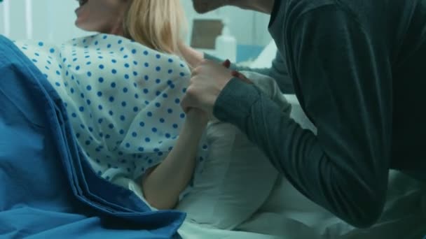 在医院特写镜头的妇女在劳动冲刺分娩 产科医生协助 丈夫握着她的手 带专业助产士的现代送货区 — 图库视频影像