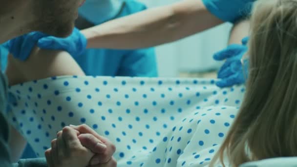 在医院分娩的妇女 丈夫牵着她的手支持 产科医生协助 带专业助产士的现代送货区 — 图库视频影像