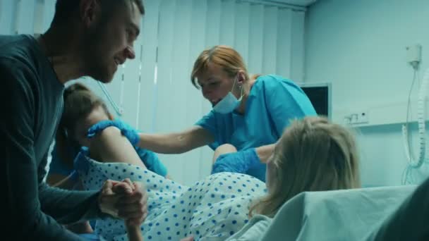 医院急诊 分娩的妇女 丈夫牵着她的手支持 产科医生协助 带专业助产士的现代送货区 — 图库视频影像