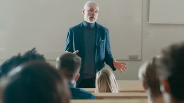 Arkadan görünüşü bir nutuk önemli bir profesöre dinleme öğrenciler ders koridorda. Parlak genç insanlar çalışma Üniversitesi'nde karizmatik öğretim görevlisi defa okundu.