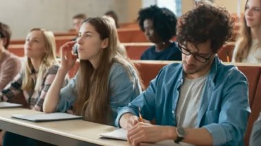 Grup çok etnik öğrenci sınıfta bir ders ve Not almak için dinleme. Üniversitesi'nde çalışma parlak gençler.