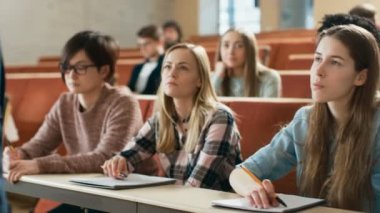 Grup çok etnik öğrenci sınava sınıf / test Bright genç insanlar çalışma Üniversitesi'nde.