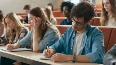 Grup çok etnik öğrenci sınava sınıf / test Bright genç insanlar çalışma Üniversitesi'nde.