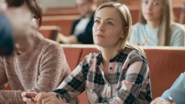 Elleri öğretim üyesi iken o bir sınıf tam öğrenci için ders verir. Gençler Üniversitesi nde bir konferans dinlerken.