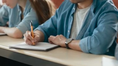 Görüntüleri bir satır çok etnik öğrencilerin sınava sınıfta hareketli / Test / not defterlerinde yazılı. Üniversitesi'nde çalışma parlak gençler.
