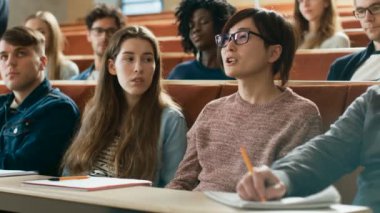 Sınıfta akıllı Asya öğrenci profesör bir soru sorar. Çok etnik grubunu Koleji'nde Modern parlak öğrencilerin.